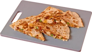 Four toasted, triangular quesadilla slices stacked on a gray cutting board, showing a filling of crispy chicken, melted cheese, bacon, and chopped green onions with a creamy sauce drizzle.